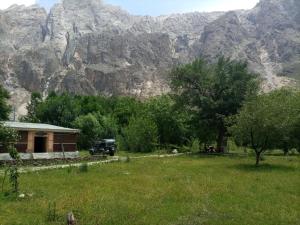a truck parked in front of a house with a mountain at Siwakhat Huts in Shoghot