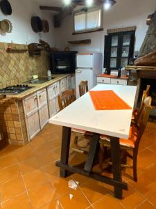una cocina con mesa y sillas. en Casa belvedere Sa Costa, en Dorgali