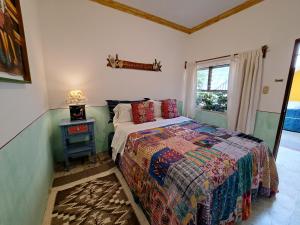 ein Schlafzimmer mit einem Bett und einem Tisch mit einer Lampe in der Unterkunft Yellow House Hostel B&B in Antigua Guatemala