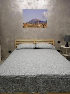 1 dormitorio con 1 cama y una pintura en la pared en B&B San Pietro, en Scafati