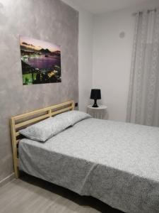 1 dormitorio con 1 cama y una pintura en la pared en B&B San Pietro, en Scafati