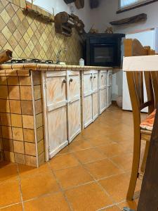 cocina con armarios de madera y suelo de baldosa en Casa belvedere Sa Costa, en Dorgali