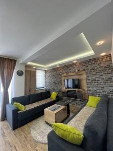Apartman LED-Treska في كوباونيك: غرفة معيشة مع أريكة زرقاء وجدار من الطوب