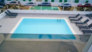 a swimming pool in a building with chairs and cars at Rociaga 35 Apartment 8, 100 meters to sea front in Puerto del Carmen