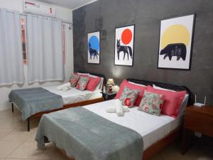 1 dormitorio con 2 camas y pinturas en la pared en Loft na Praia de Copacabana, maquina de lavar, en Río de Janeiro
