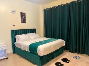um quarto com uma cama com cortinas e sapatos verdes em Spacious 1,2 bedroom all master ensuit with a lake view em Nakuru