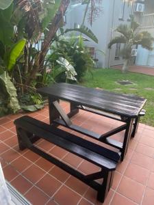 a wooden bench sitting on a red tile floor at The Bridge UNIT 23 St Lucia in St Lucia