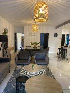 un salon avec des canapés, des chaises et une table dans l'établissement Ground floor 3-bedroom Apartment on the Estuary, à St Lucia