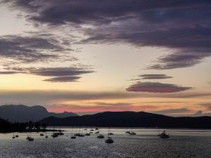 a group of boats in the water at sunset at The Manessi City Boutique Hotel in Poros