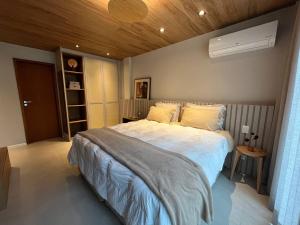 1 dormitorio con 1 cama grande y techo de madera en Casa 13 da Villa - Fazenda Marambaia, en Petrópolis