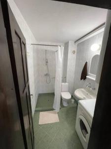 uma casa de banho com um chuveiro, um WC e um lavatório. em Quiet central studio em Pazardzhik
