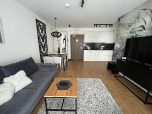 uma sala de estar com um sofá e uma mesa em Stone Hill SPA by Clima Apartment em Szklarska Poręba