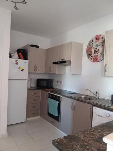 a kitchen with white appliances and a white refrigerator at Tala Gardens Apartment in Tala