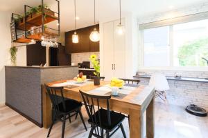 a kitchen and dining room with a wooden table and chairs at TEINE WHITE HOUSE in Sapporo