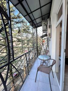 un balcón con mesa y sillas. en Mon Apartment, en Kutaisi