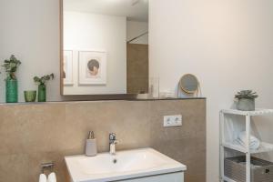 W łazience znajduje się umywalka i lustro. w obiekcie SHINY HOMES - City Center with Parking Place w mieście Gütersloh