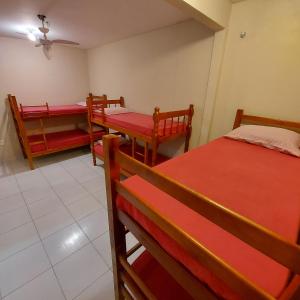 a room with three beds and two tables and chairs at Eco Isla GuestHouse in Florianópolis