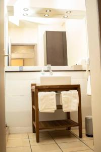 bagno con lavandino e specchio di NOUVEAUTÉ CLÉ EN MAIN - L'EDEN - STUDIO HOTEL CARAYOU: BAR, PISCINE, PLAGES a Les Trois-Îlets