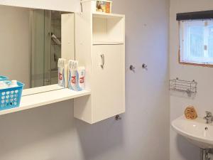 een witte badkamer met een wastafel en een spiegel bij Holiday home HÖKERUM II in Hökerum