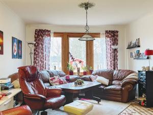 a living room with a leather couch and a table at Holiday home ÅMÅL in Åmål