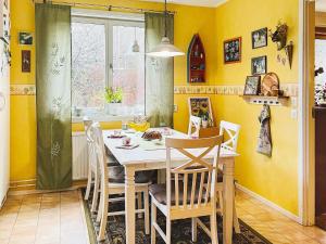 a dining room with yellow walls and a table and chairs at Holiday home ÅMÅL in Åmål