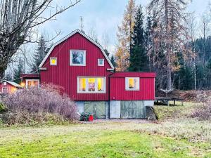 una casa roja con techo rojo en un campo en Holiday home ÅMÅL en Åmål