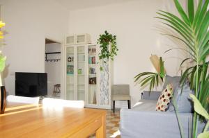 uma sala de estar com um sofá e uma televisão em Incantevole Appartamento De Angeli em Milão