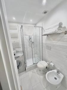 ein weißes Bad mit einer Dusche und einem WC in der Unterkunft Madonna dei Monti in Rom