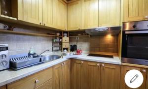 a kitchen with wooden cabinets and a sink and a microwave at Holiday Home Bianca in Kolašin