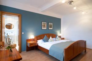 1 dormitorio con cama y pared azul en Gasthaus zum Schwan, en Castell