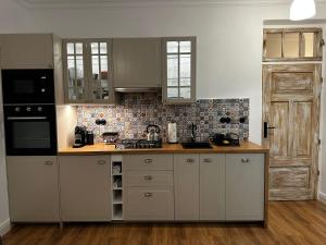 a kitchen with white cabinets and a black appliances at Orlicz 32 Apartments in Zamość