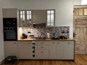 Una cocina con gabinetes blancos y encimera. en Orlicz 32 Apartments, en Zamość 74 fotos más
