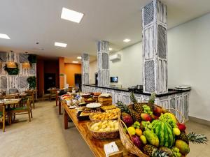 une longue table remplie de nombreux fruits et légumes dans l'établissement Gaeta Hotel, à Guarapari