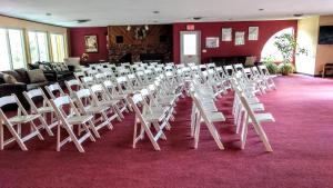 a room with rows of white chairs on a red carpet at Cathedral Ledge Resort in North Conway