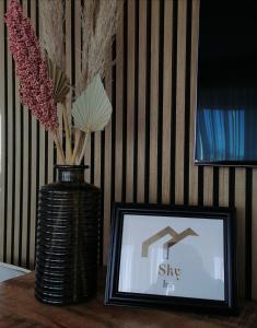 um vaso com flores e uma foto numa mesa em SKY INN - nahe Messe contactless check in em Hanôver