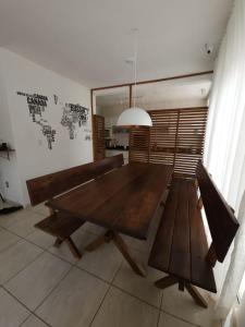 comedor con mesa de madera y bancos en Eco Isla GuestHouse, en Florianópolis