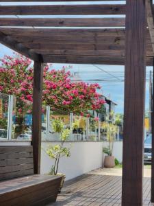 a pergola with pink bougainvillea in the background at Eco Isla GuestHouse in Florianópolis