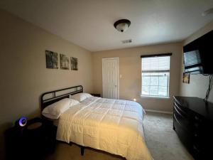 1 dormitorio con cama y ventana en Cozy 3-bed Garden Home - 10 mins to UT Stadium and Downtown Austin, en Austin