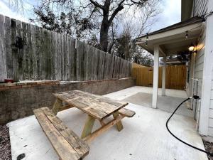 einen hölzernen Picknicktisch neben einem Zaun in der Unterkunft Cozy 3-bed Garden Home - 10 mins to UT Stadium and Downtown Austin in Austin
