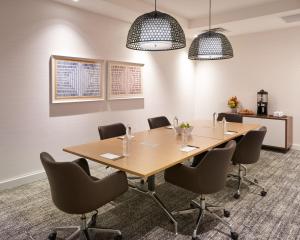 una sala de conferencias con mesa de madera y sillas en Staybridge Suites Wilmington Downtown, an IHG Hotel, en Wilmington