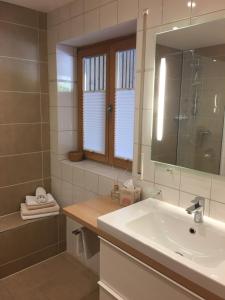 La salle de bains est pourvue d'un lavabo, d'une douche et d'un miroir. dans l'établissement Ferienwohnung Martina Bauer, à Oberammergau