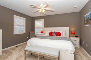 a bedroom with a white bed and a ceiling fan at Hoosier Happiness, Too! 3 Bedroom Suites Near IU & Downtown in Bloomington