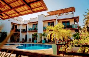 a resort with a swimming pool and a building at Pousada Morada do Sol in Camocim