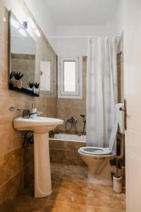y baño con lavabo, aseo y bañera. en Alexandros Apartments, en Mesolongi
