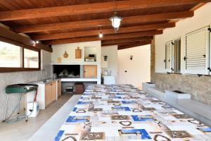 una cucina con un lungo tavolo con fotografie di Villa Sara a Lotzorai