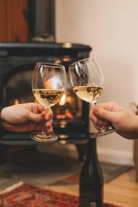 two people holding wine glasses in front of a fireplace at Anchor Inn in Traverse City