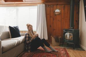 a woman sitting on a couch holding a cell phone at Anchor Inn in Traverse City