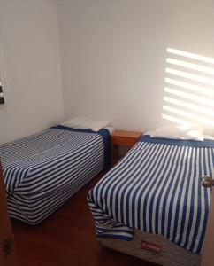 two beds sitting next to each other in a room at Depto huasco in Huasco