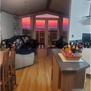a kitchen and living room with a view of the sunset at Heysham seaview in Heysham