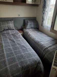 2 Betten nebeneinander in einem Zimmer in der Unterkunft Heysham seaview in Heysham